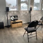 chairs and speakers in a gallery with tree like light pattern.