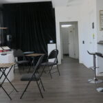 Cafe chairs and tables amidst record players and mini TV display.